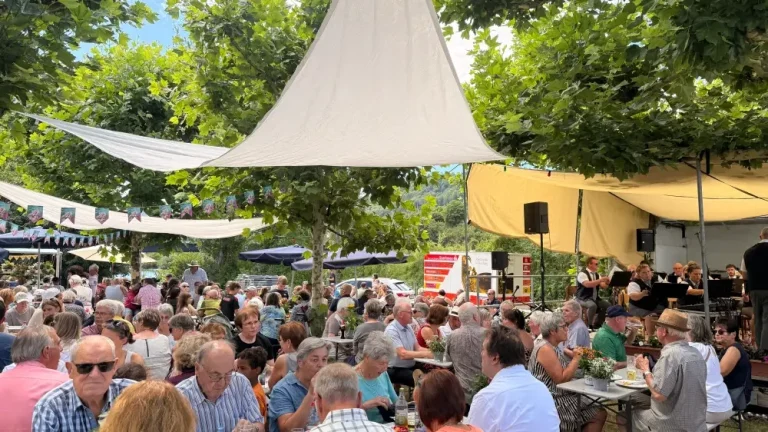 Die Vorstandschaft des Musikvereins. Gruppe von neun Personen, lächelnd, vor einer neutralen Wand.