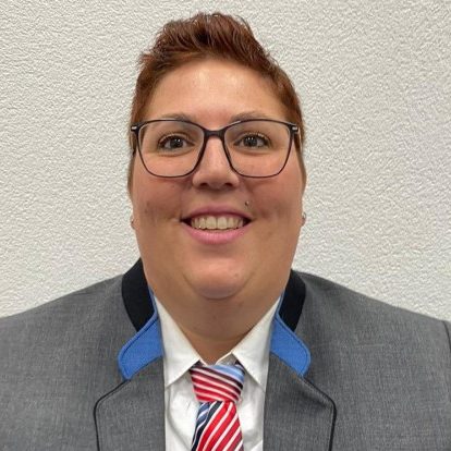 Sybill Starkmann, Jugendausbildung. Lächelnde Frau mit kurzer brauner Frisur und Brille, in der Uniform des Musikvereins Rheinheim.