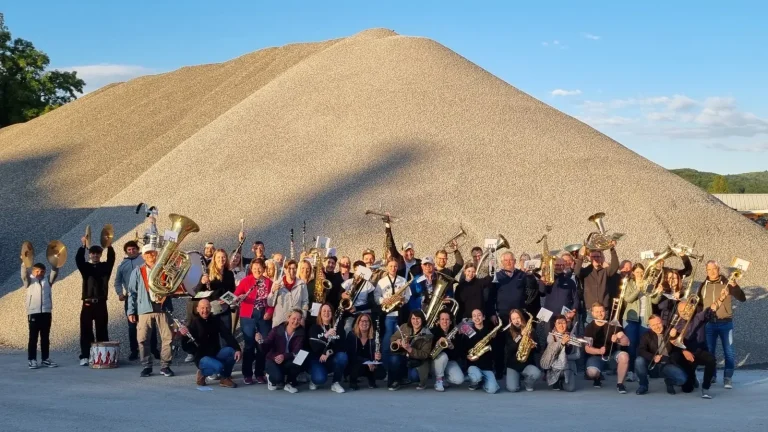 Die Vorstandschaft des Musikvereins. Gruppe von neun Personen, lächelnd, vor einer neutralen Wand.